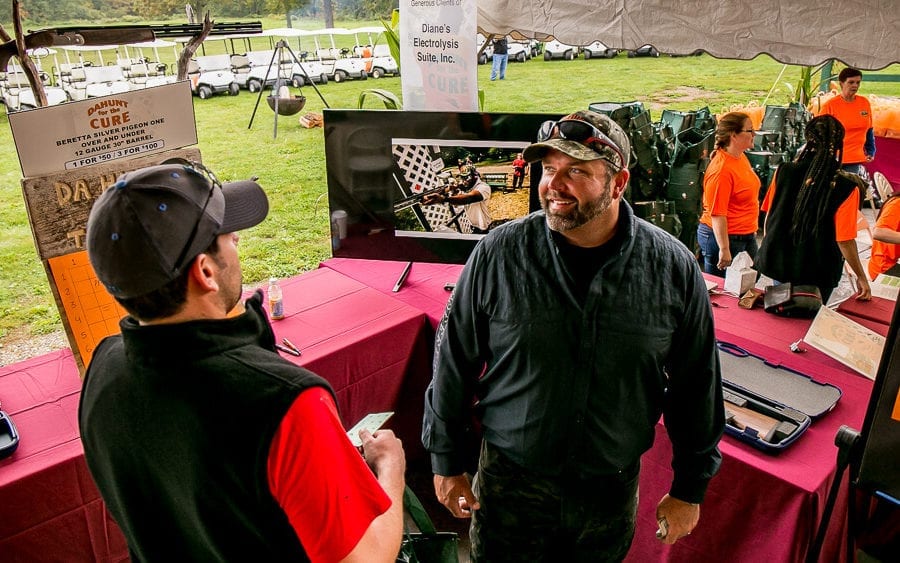 Two men talking at outdoor vendor booth