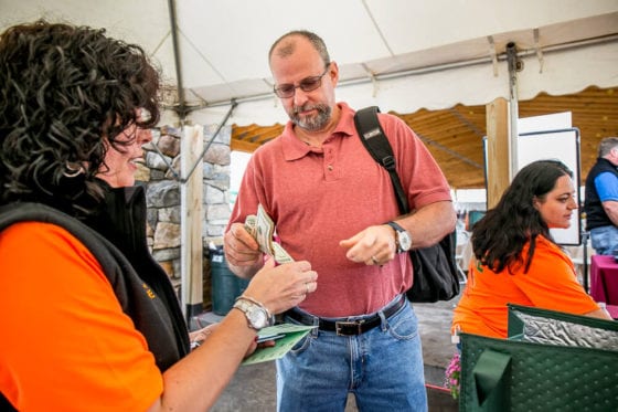 Man handing cash at event registration table