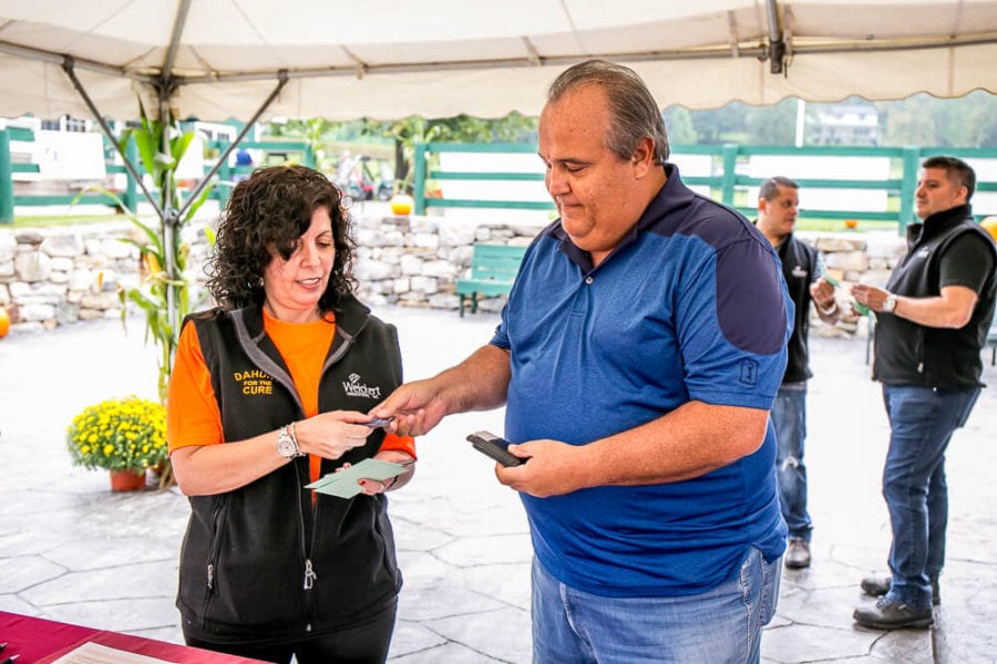 Woman checking man in at outdoor booth