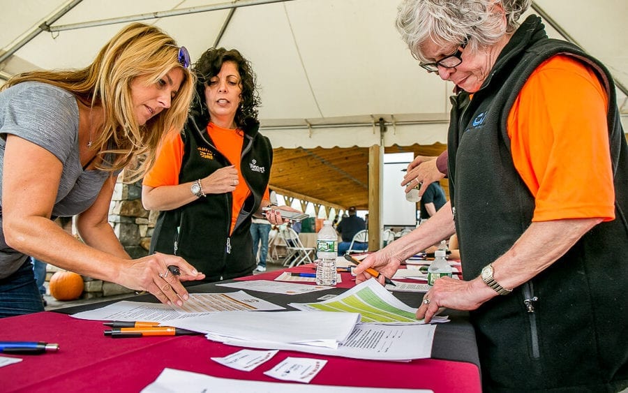 Volunteers reviewing registration forms at event