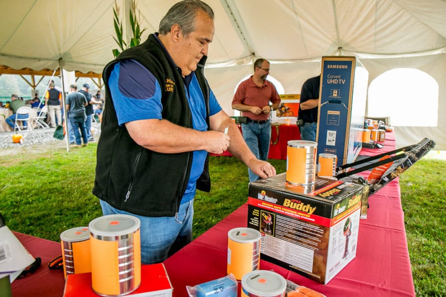 Man arranging paint cans on vendor table