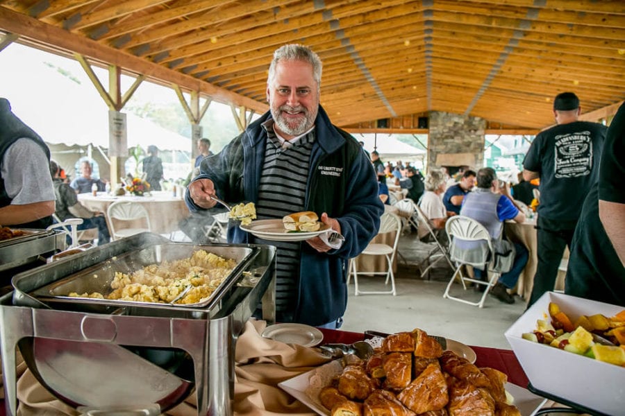 Smiling man serving food at outdoor buffet