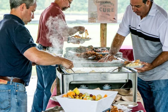 People serving themselves at outdoor buffet