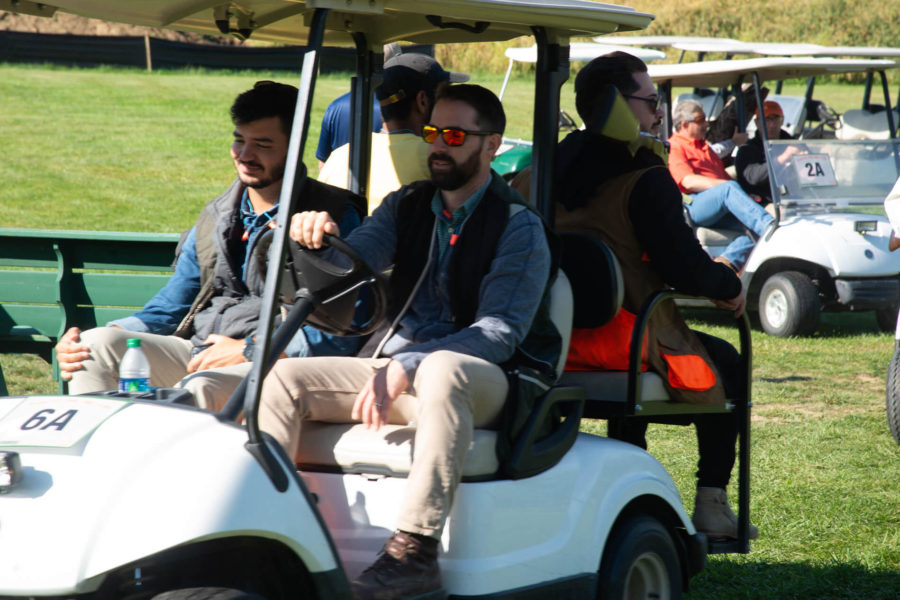 People seated in golf cart on grass
