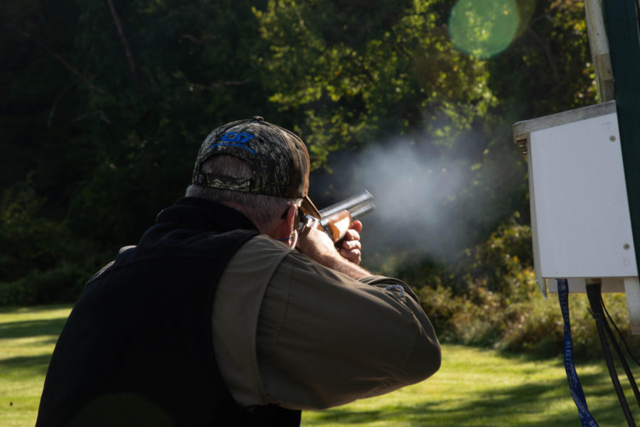Person firing shotgun at outdoor shooting range