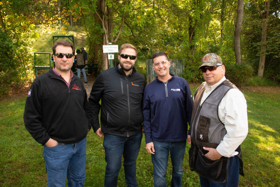 Four men standing in wooded shooting range