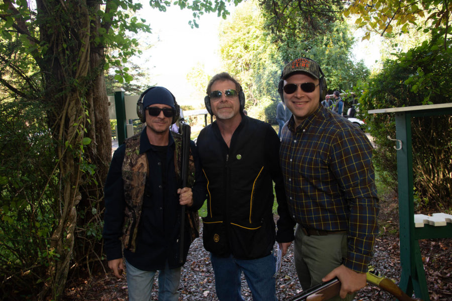 Three men with shotguns at outdoor shooting range