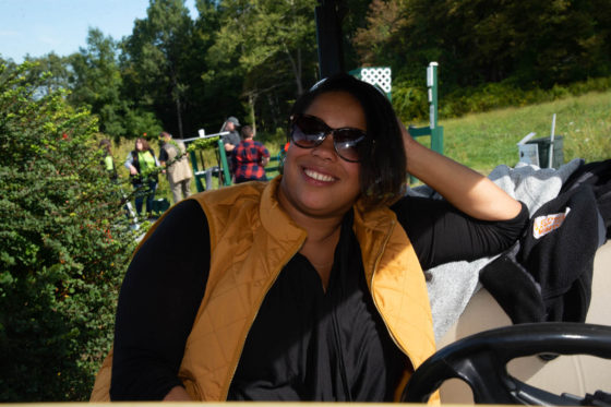 Smiling woman in sunglasses and yellow vest outdoors