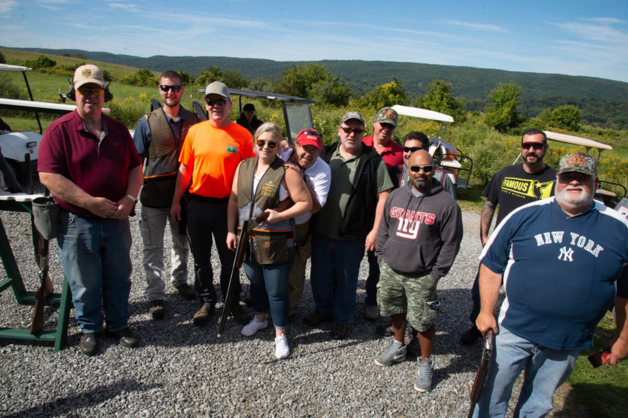 Group of shooters posing at outdoor shooting range