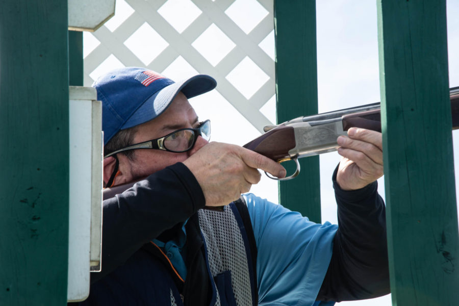 Clay target shooter aiming shotgun at station