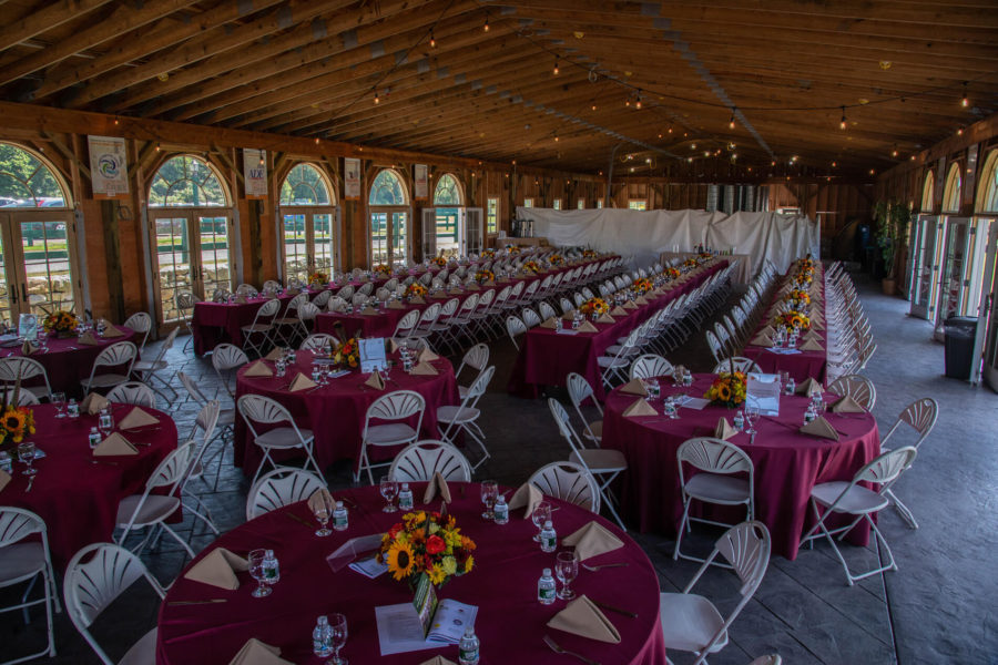 Banquet hall with maroon tablecloths and chairs