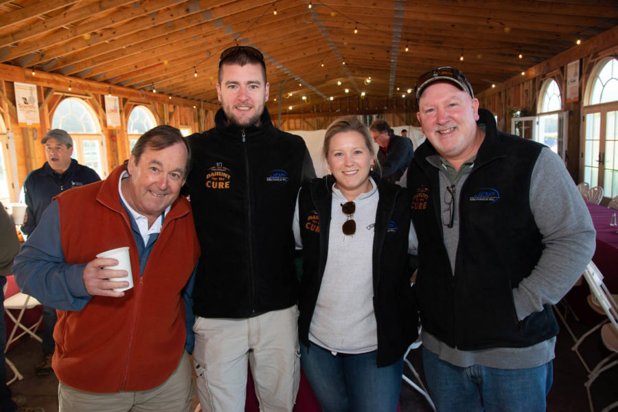 Four smiling adults in wooden event pavilion