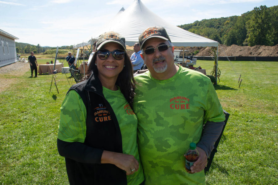 Two volunteers in green shirts at outdoor event