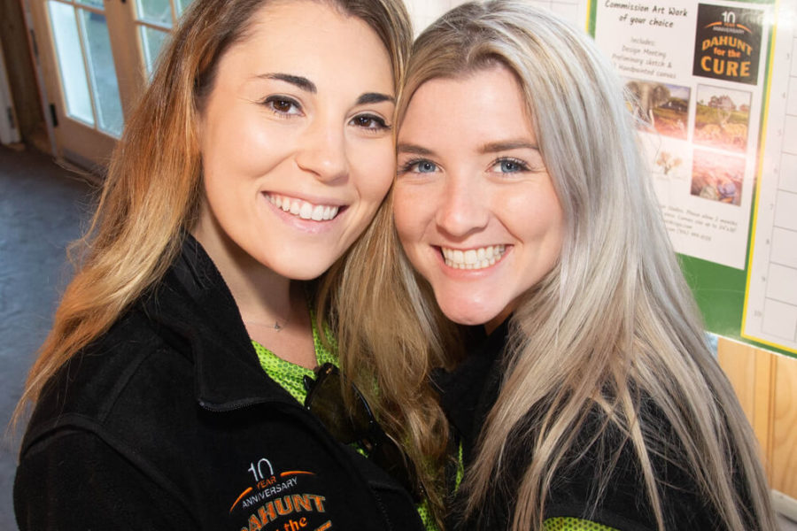 Two smiling women at indoor event