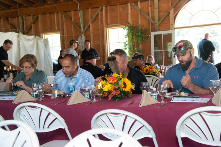 Guests seated at banquet table with sunflower centerpiece