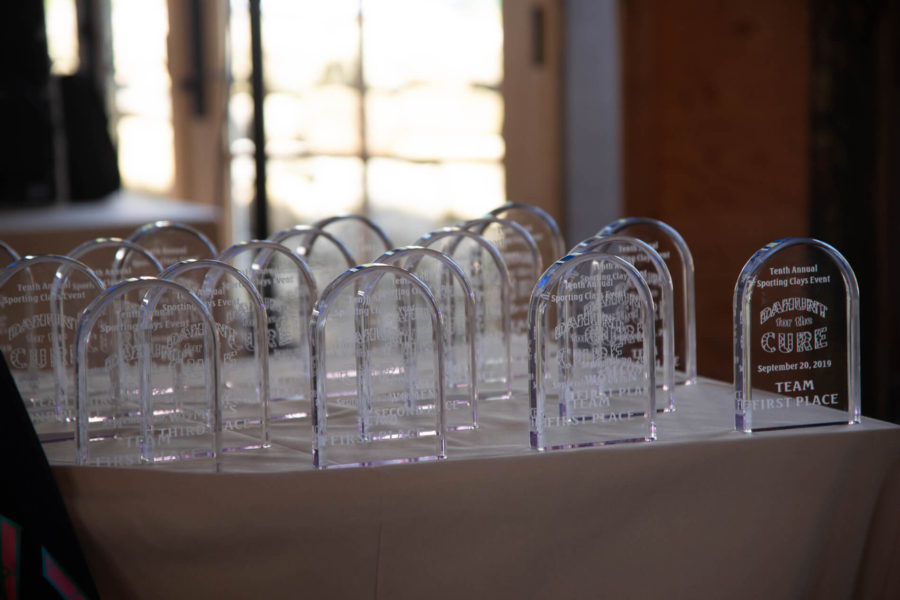 Multiple clear trophies lined up on table