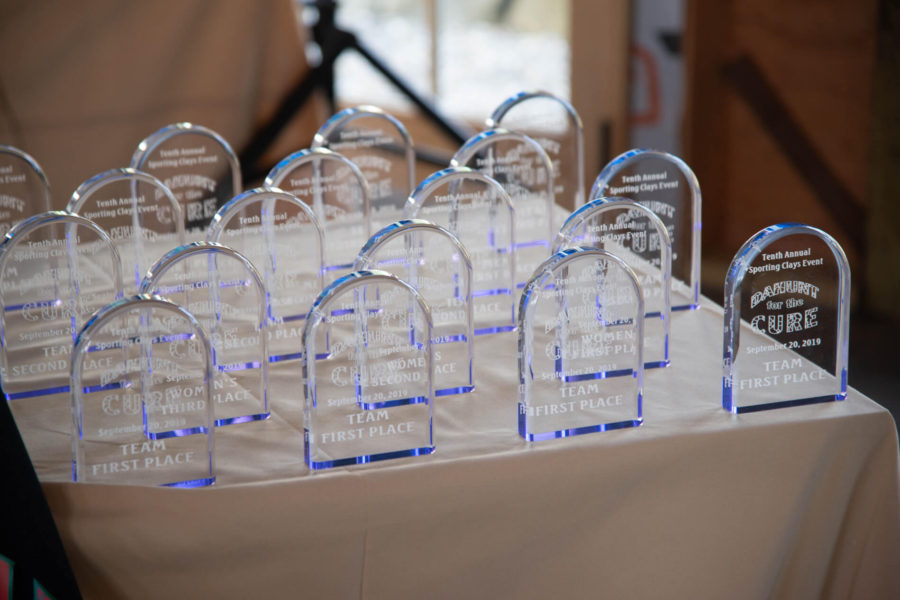 Multiple clear acrylic first-place trophies on table