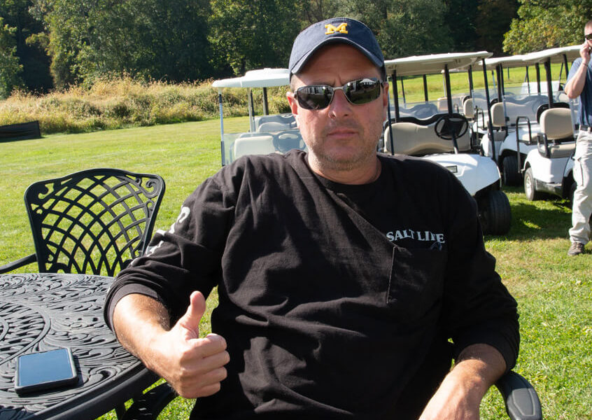 Man giving thumbs up near parked golf carts
