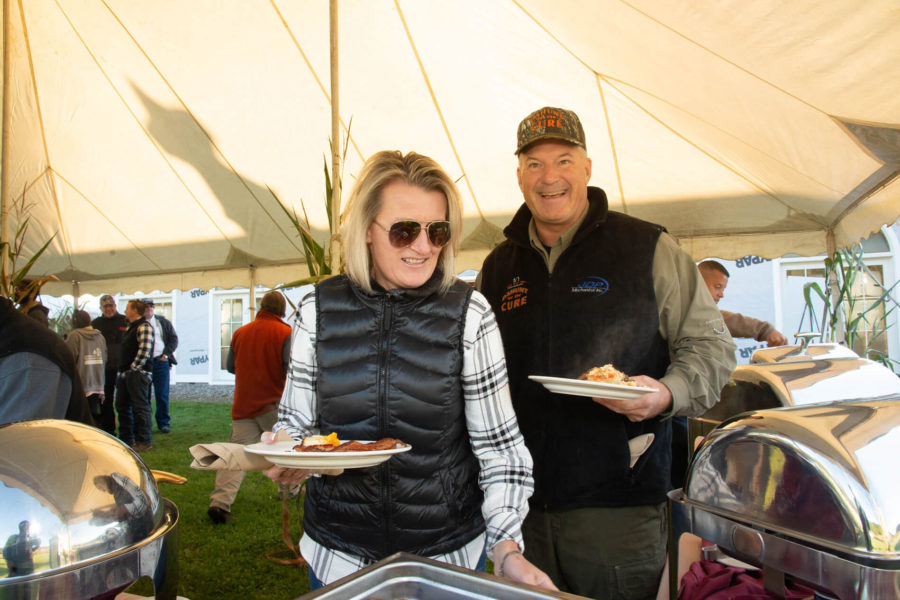 Couple smiling at outdoor buffet under tent