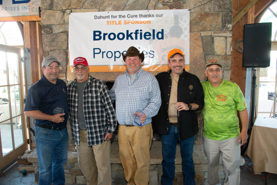 Five men in front of Brookfield banner