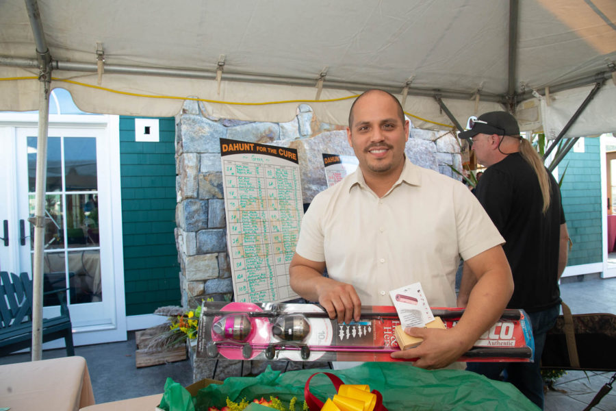 Smiling man holding boxed prize under tent