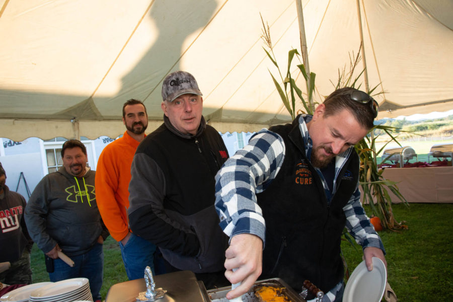 Men serving themselves food at outdoor buffet