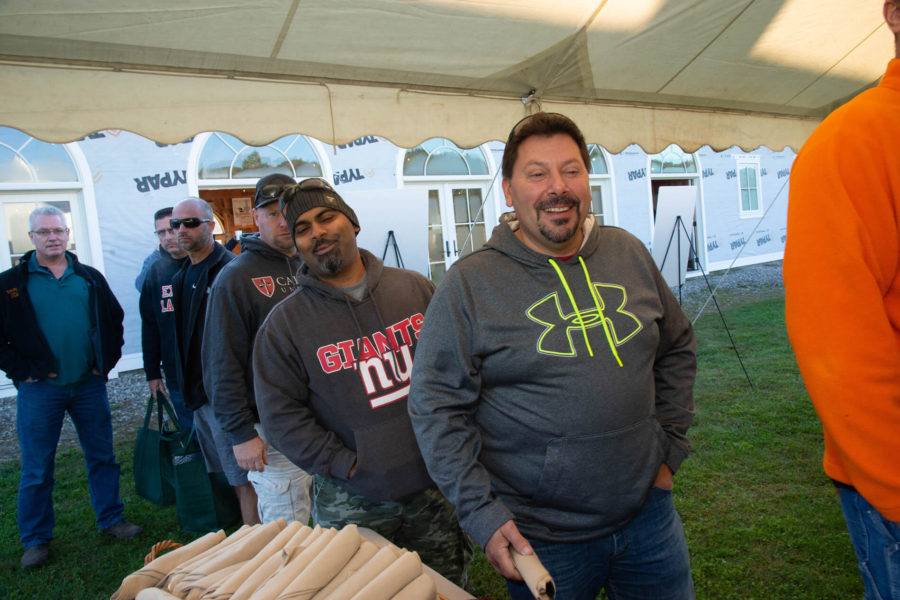 Group of men smiling in event tent