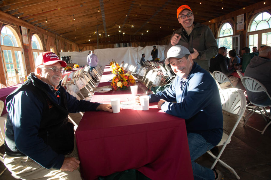 Three men smiling at banquet table