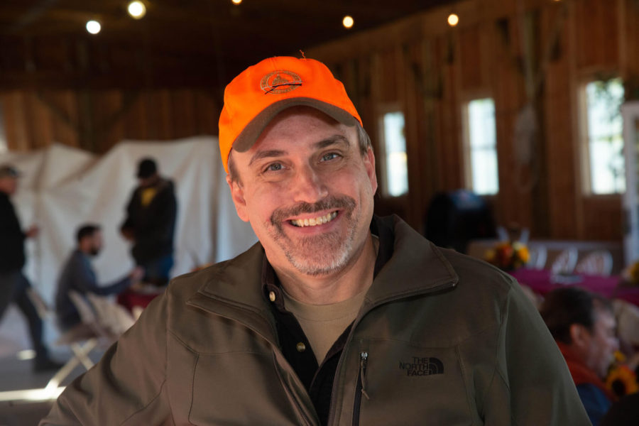 Smiling man in orange cap at indoor event