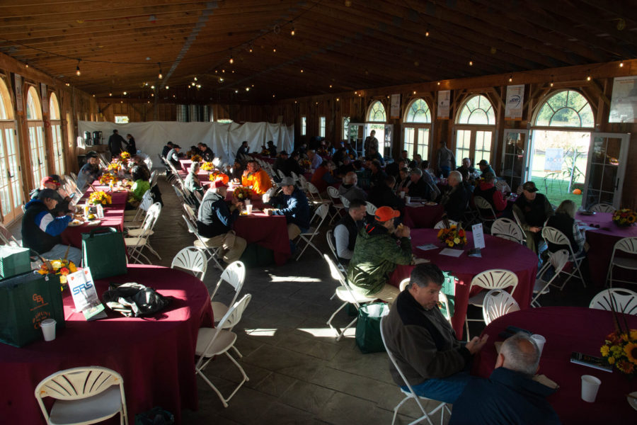 People seated at tables in wooden hall