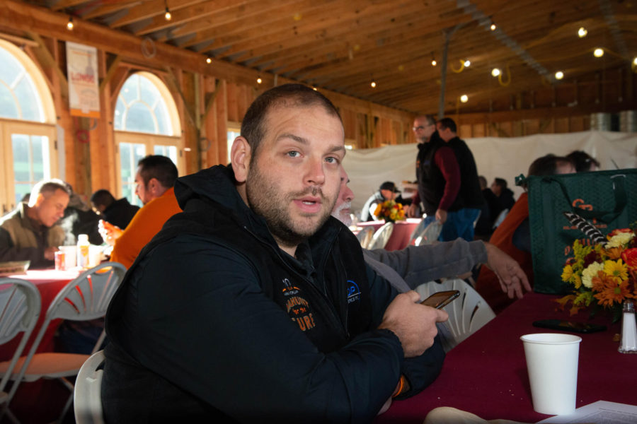Man holding phone at table in wooden hall