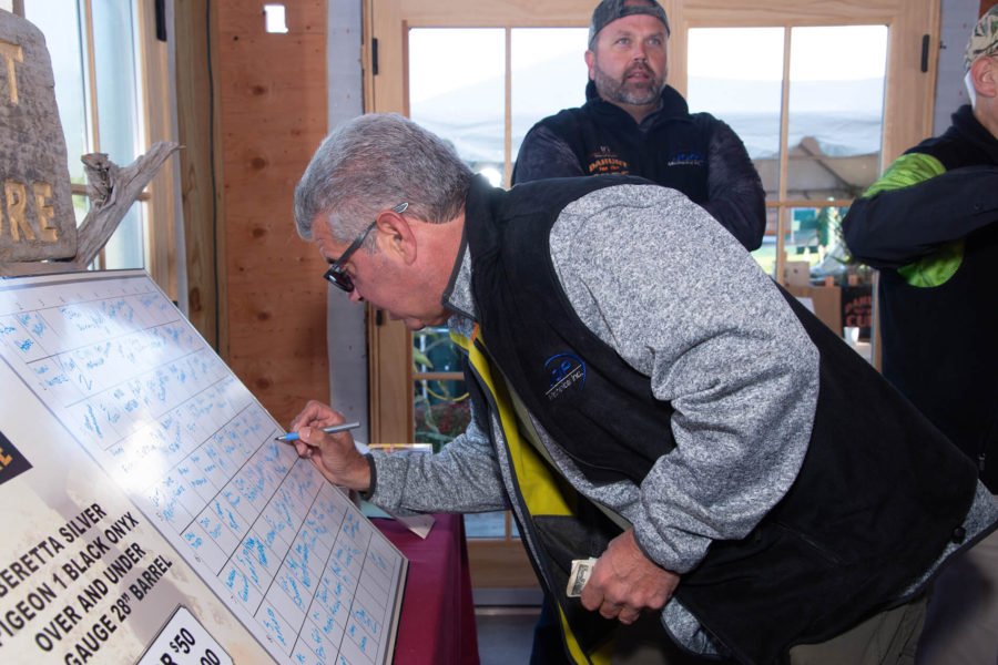 Man writing on large tournament scoreboard