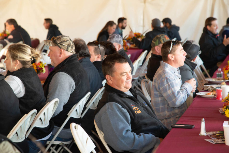 People seated in tent at communal meal