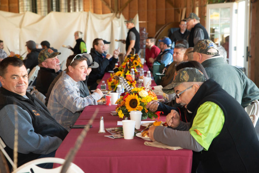 People eating at sunflower decorated harvest table
