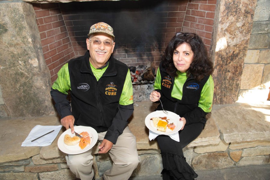 Two people eating by stone fireplace