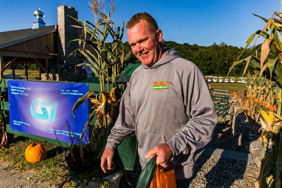 Smiling man at pumpkin patch holding bag