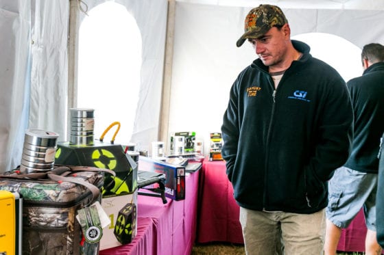 Man inspecting hunting gear at indoor expo