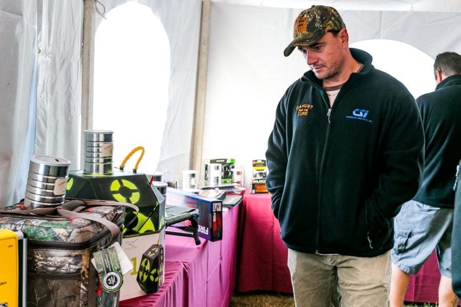 Man inspecting hunting gear at indoor expo