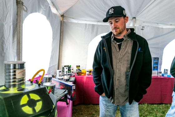 Man wearing Yankees cap inspects equipment in tent
