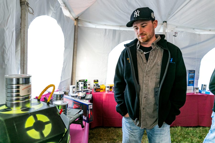 Man wearing Yankees cap inspects equipment in tent