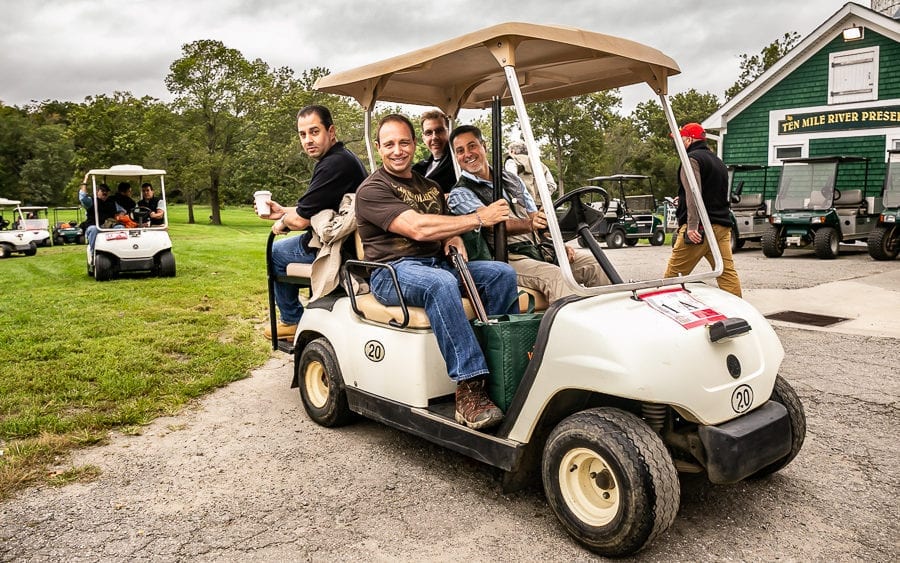 Men riding golf cart at golf course