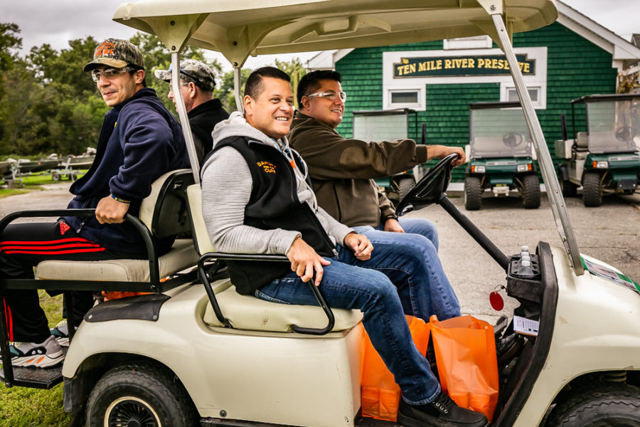 Four people smiling in golf cart outdoors
