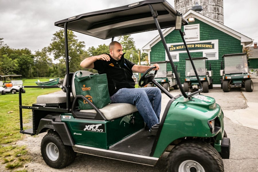 Man driving green golf cart near clubhouse