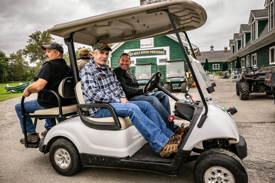 Group of men riding in white golf cart