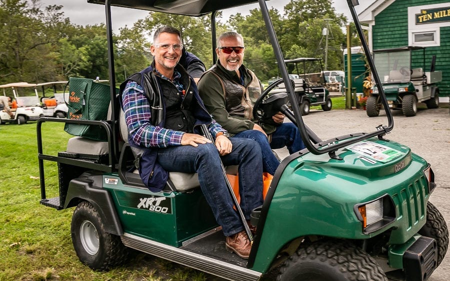 Two men smiling in green golf cart