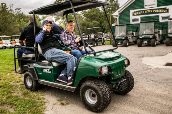 Two men in green golf cart at preserve