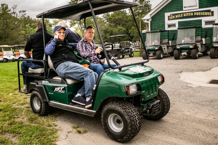 Two men in green golf cart at preserve