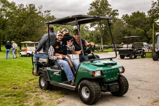Men smiling in green golf cart