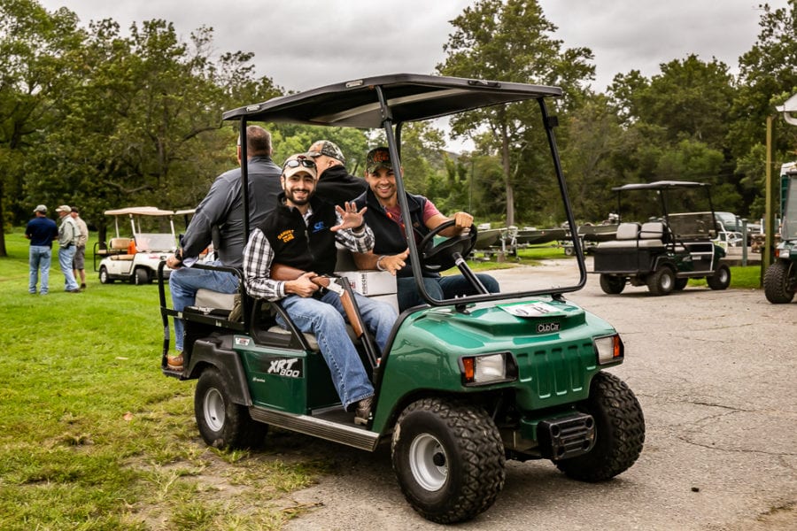 Men smiling in green golf cart