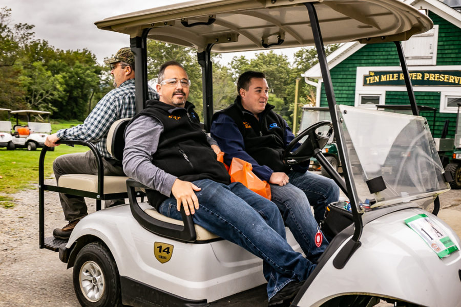 Three men in white golf cart